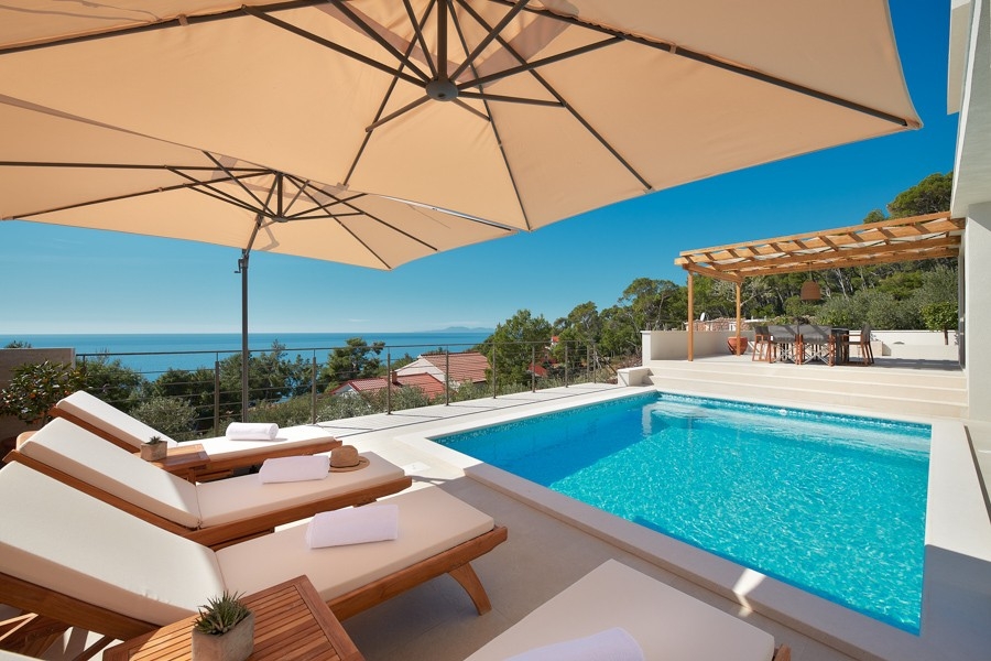 Terrasse de la piscine avec bains de soleil et parasol
