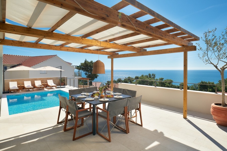 Espace repas sous la pergola avec vue mer