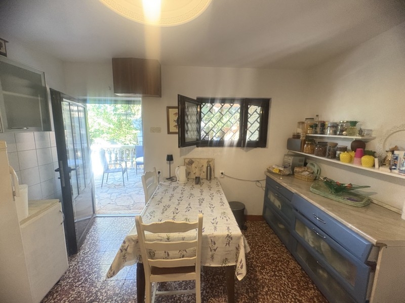 Cuisine avec table à manger et porte donnant sur la terrasse