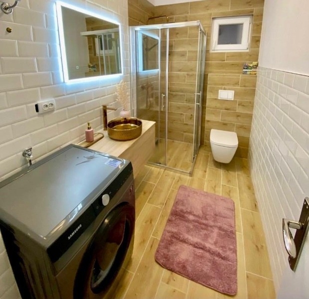 Salle de bains avec douche et lave-linge
