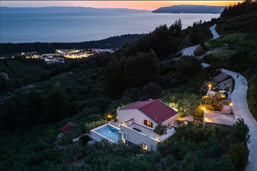 Villa à flanc de colline avec piscine éclairée le soir