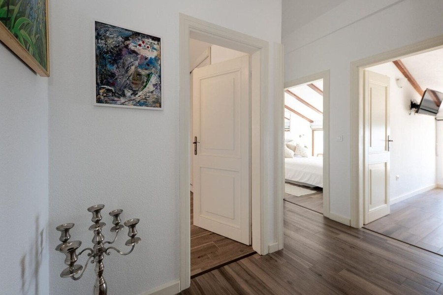 Couloir avec parquet menant aux chambres