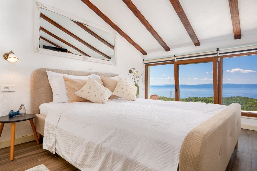 Chambre avec poutres en bois et vue mer