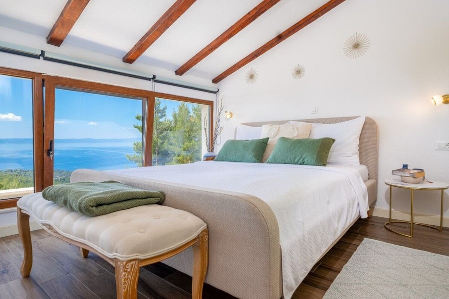Chambre avec grande baie vitrée donnant sur la mer