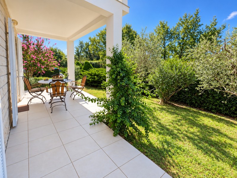 Terrasse couverte avec coin salon donnant sur le jardin