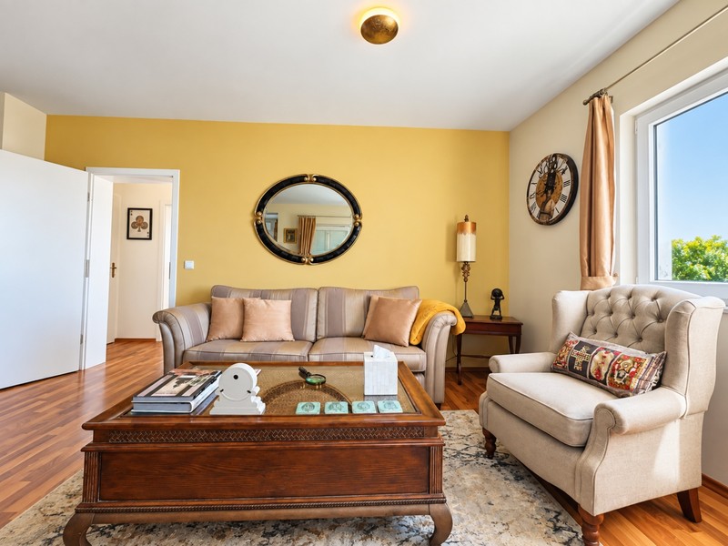 Salon avec mur jaune et fauteuil