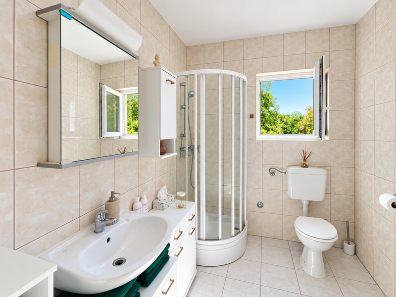 Salle de bains avec cabine de douche et fenêtre