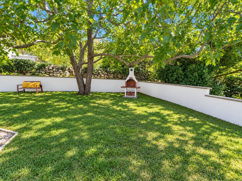 Jardin avec pelouse, arbre et coin grill