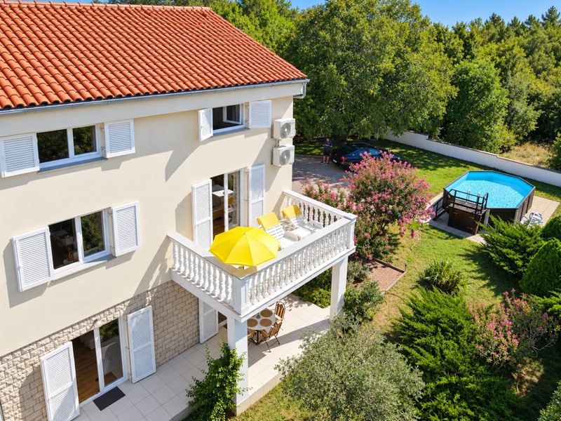 Balcon avec chaises longues au-dessus du jardin avec piscine