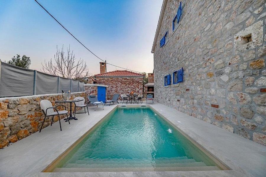 Piscine devant la façade en pierre naturelle