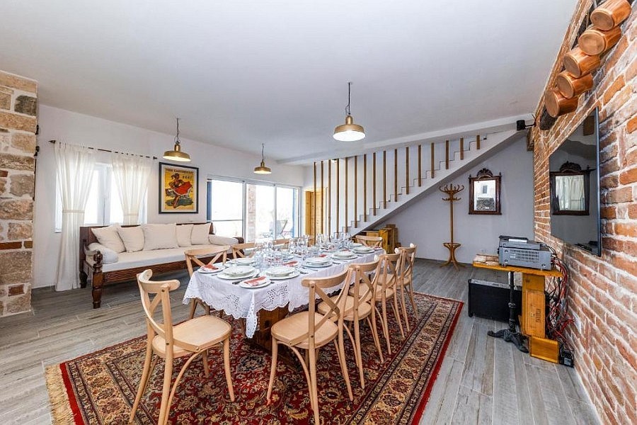 Salon avec table à manger et escalier vers l'étage