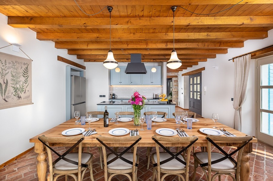 Table à manger avec chaises en bois devant une cuisine bleue