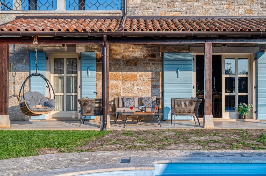 Coin salon sous l'auvent de la terrasse à côté de la piscine