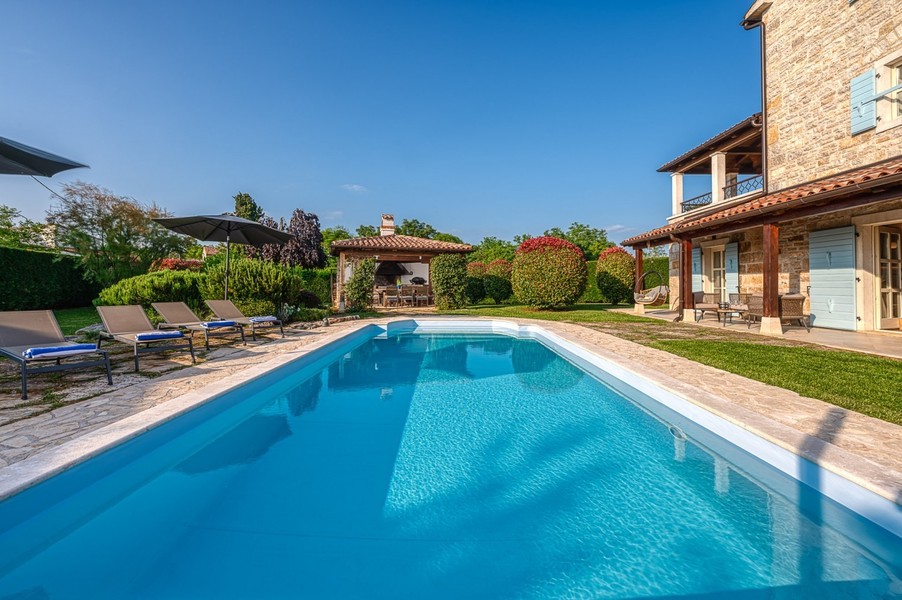 Piscine avec vue sur le pavillon de jardin et la maison
