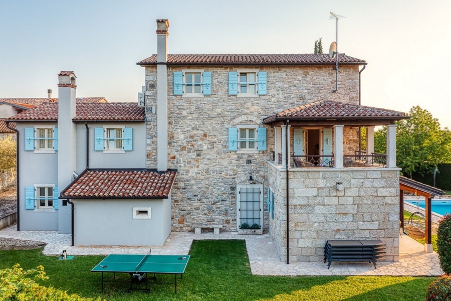 Vue latérale de la maison en pierre avec pelouse et cheminées