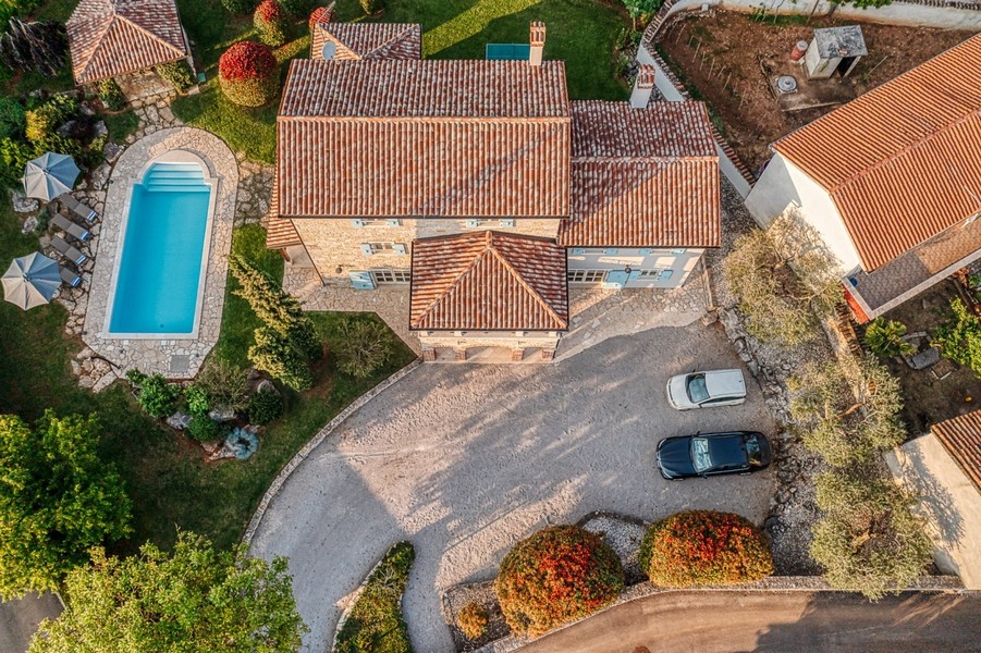 Maison avec toit en tuiles, piscine et parking vus d'en haut