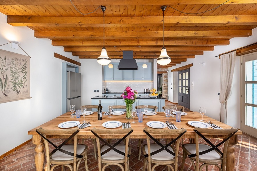 Table dressée dans la cuisine avec plafond à poutres apparentes