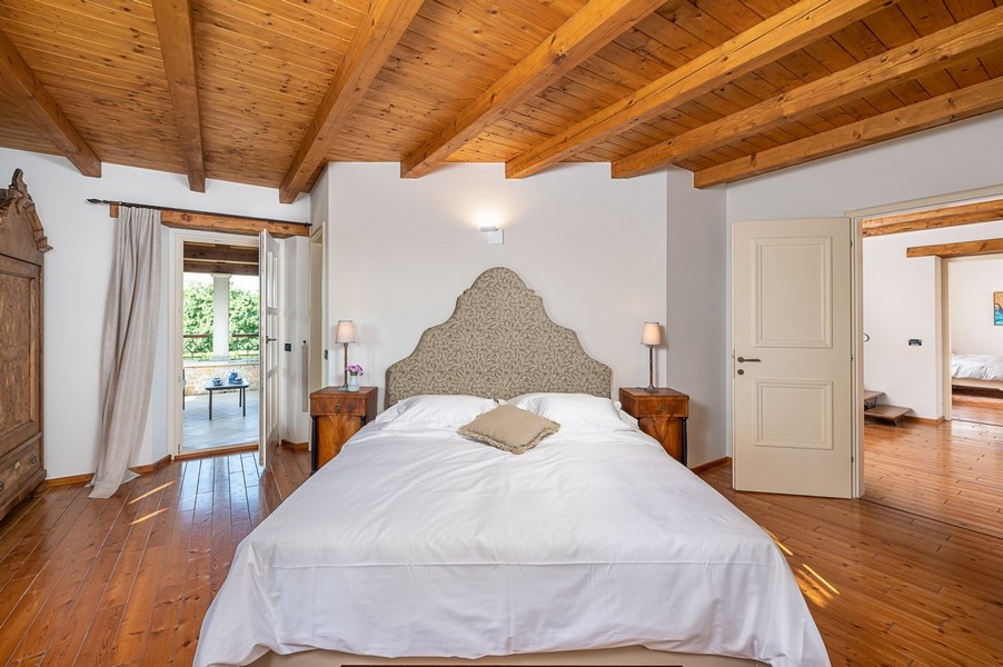 Chambre avec tête de lit capitonnée et parquet