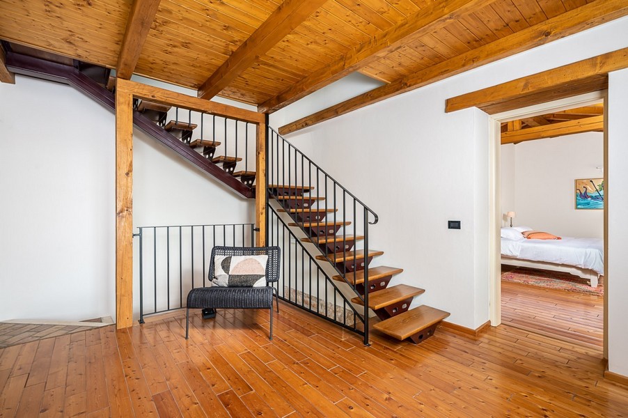 Montée d'escalier avec fauteuil et vue sur la chambre