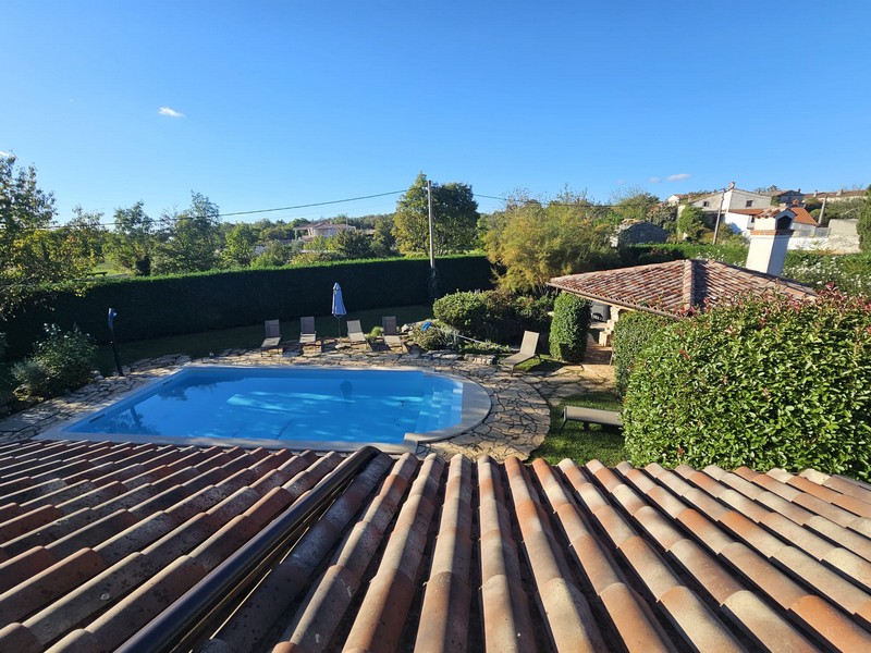 Vue sur le toit en tuiles, la piscine et les environs