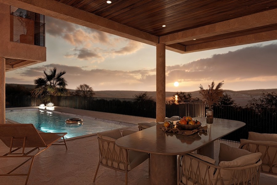 Terrasse couverte avec piscine au coucher du soleil