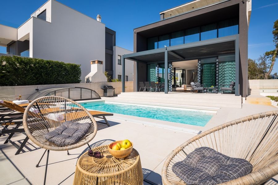 Espace piscine avec fauteuils suspendus et grill