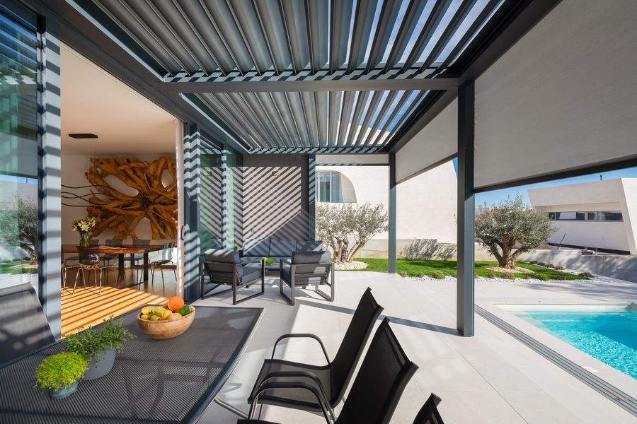 Terrasse couverte avec table à manger au bord de la piscine