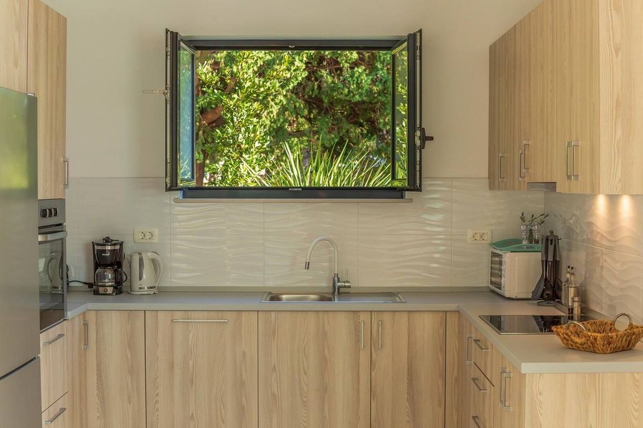 Cuisine avec façades en bois et fenêtre