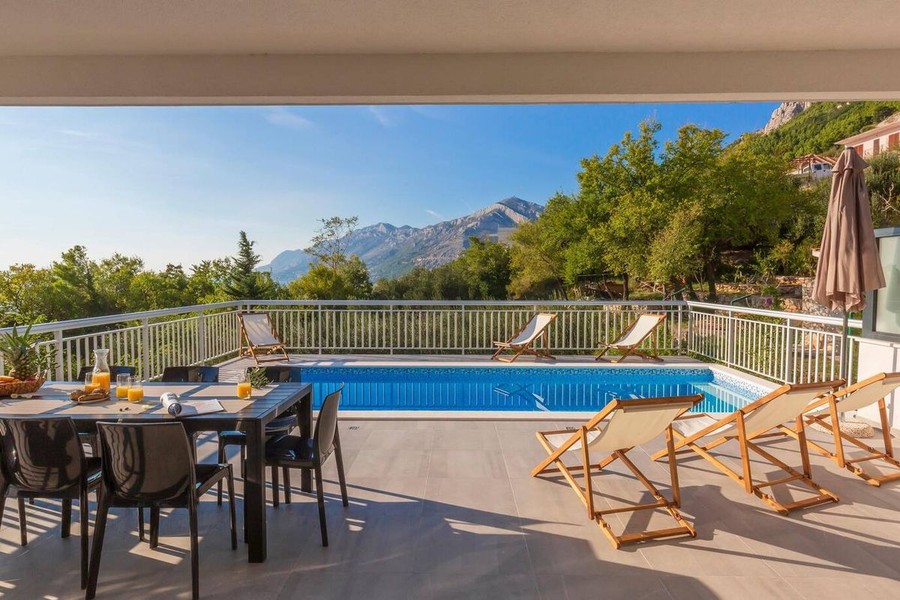Piscine avec bains de soleil et vue sur la montagne