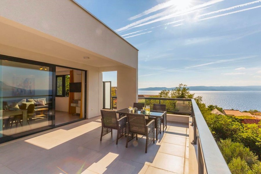 Terrasse avec table à manger et vue sur la mer