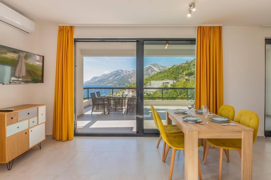 Espace repas avec chaises jaunes et vue mer