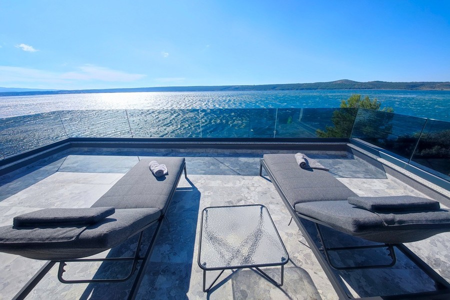 Terrasse avec bains de soleil au-dessus de la mer