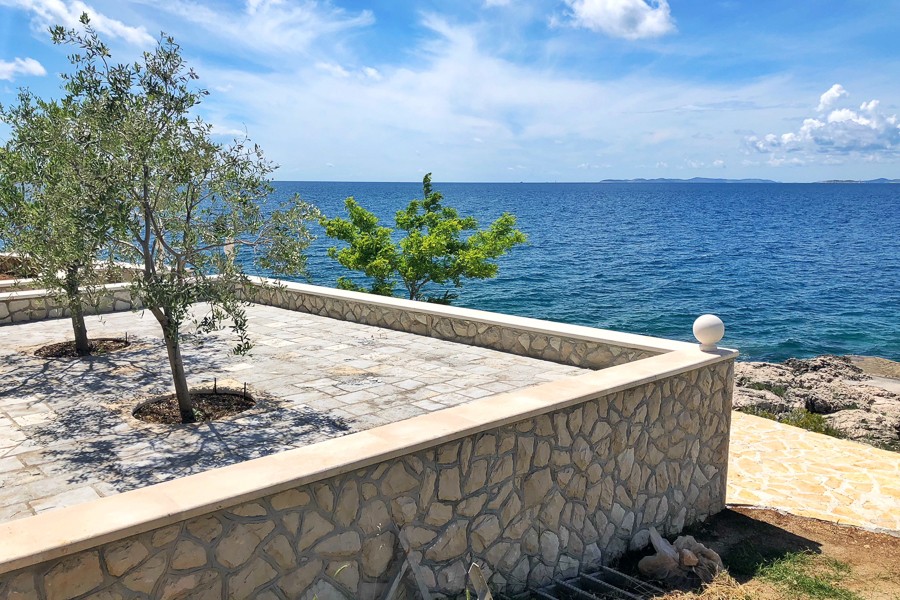 Terrasse en pierre avec oliviers au bord de la mer