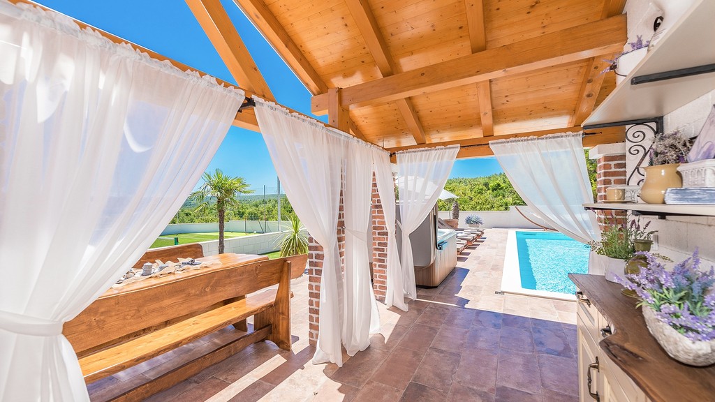 Terrasse avec toit en bois et vue sur la piscine