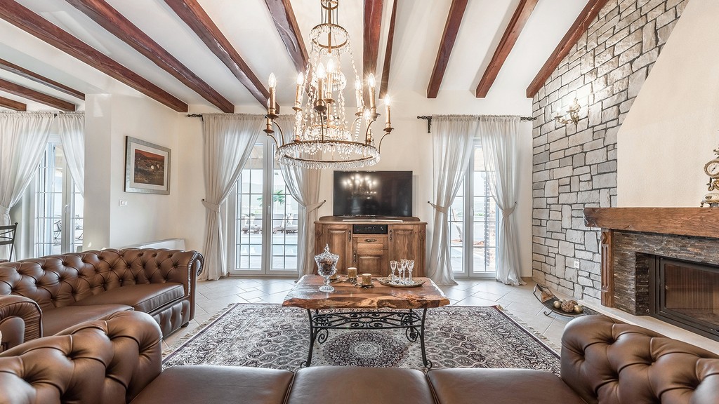 Salon avec poutres en bois et lustre