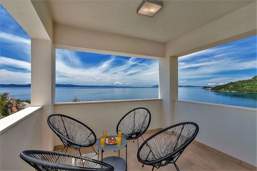 Terrasse couverte avec fauteuils et vue mer