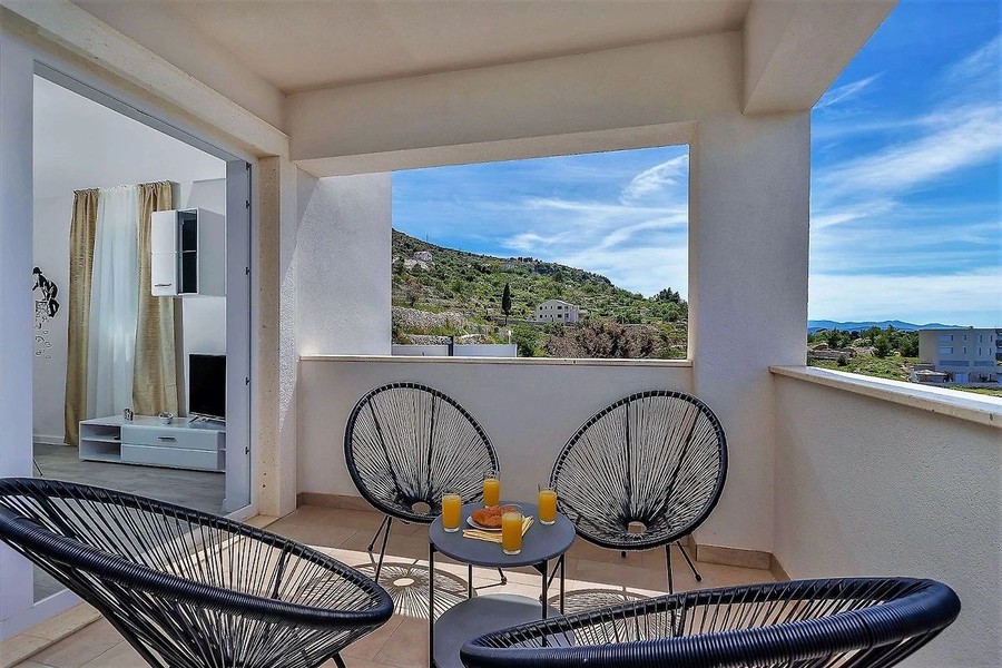 Terrasse avec fauteuils en osier et vue sur la côte