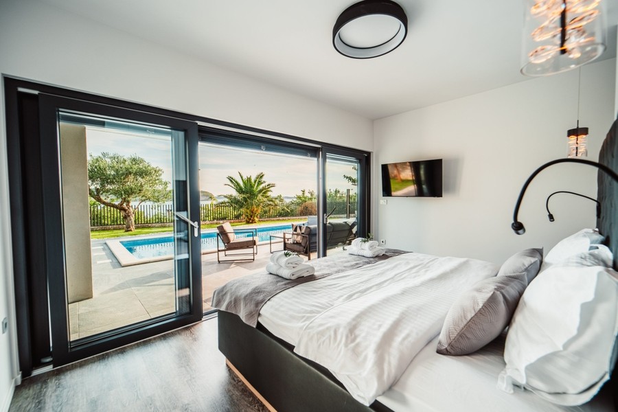 Chambre avec façade vitrée donnant sur la piscine