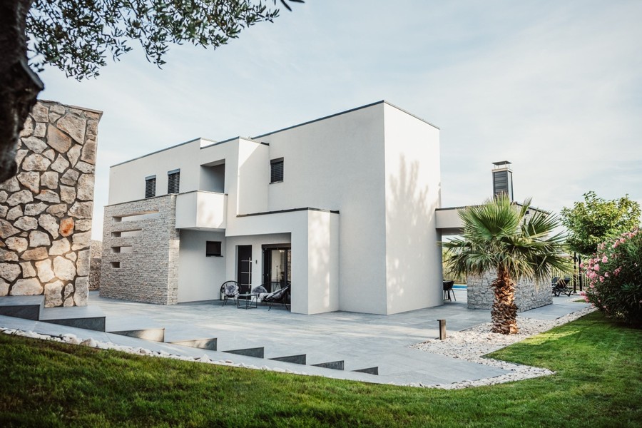 Villa moderne avec pelouse et façade en pierre