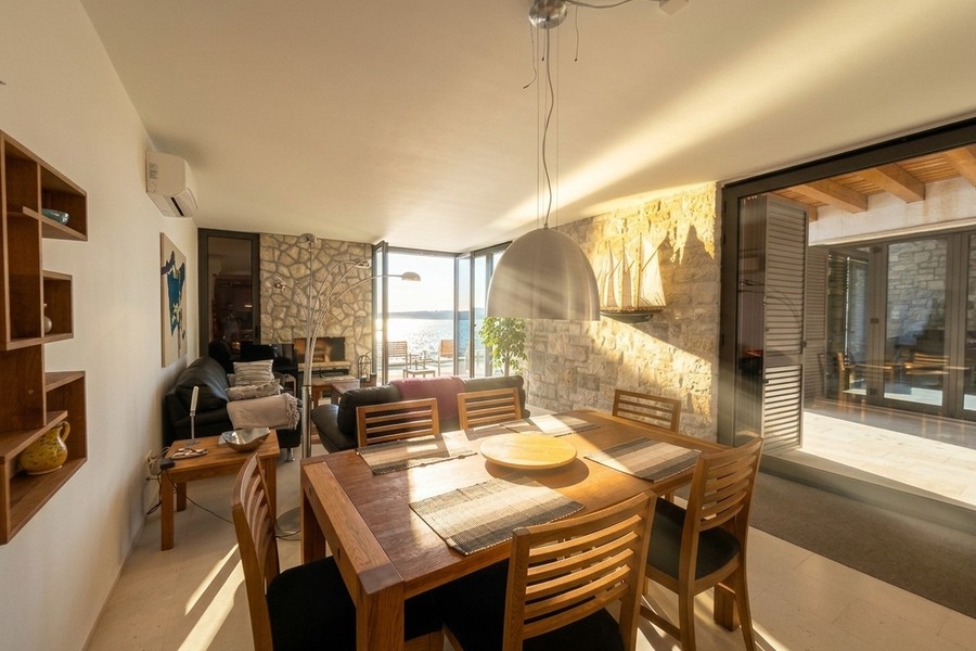 Table à manger devant la façade vitrée donnant sur la mer