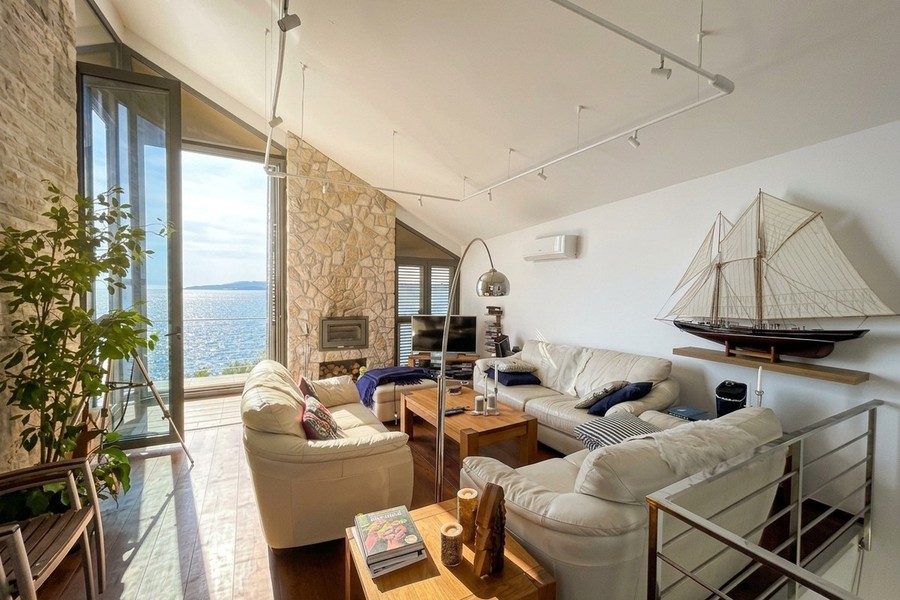 Salon avec maquette de voilier et vue mer