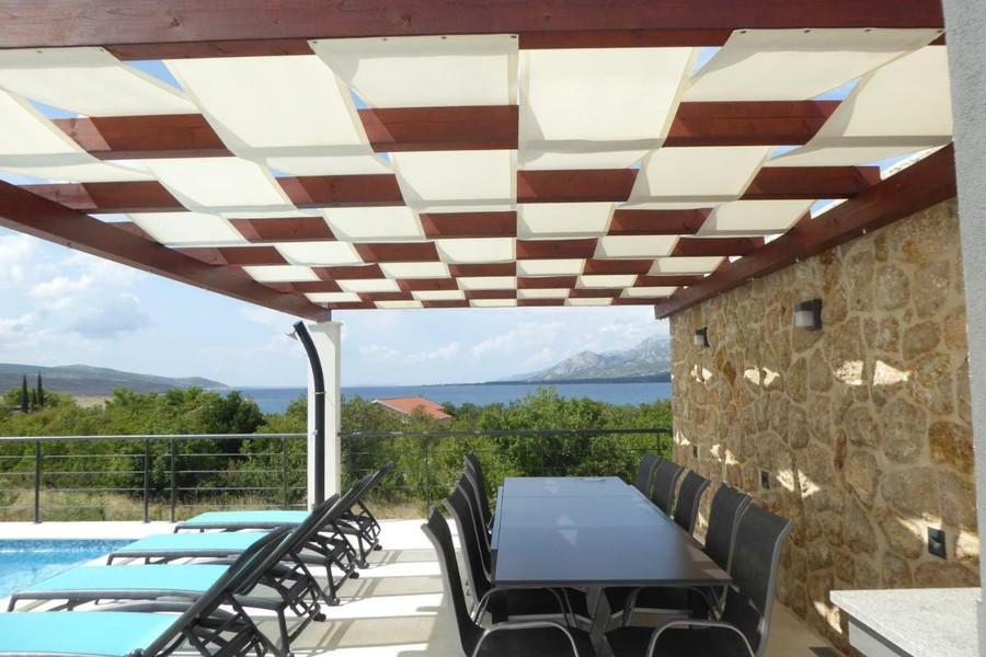 Terrasse couverte avec table à manger et vue mer