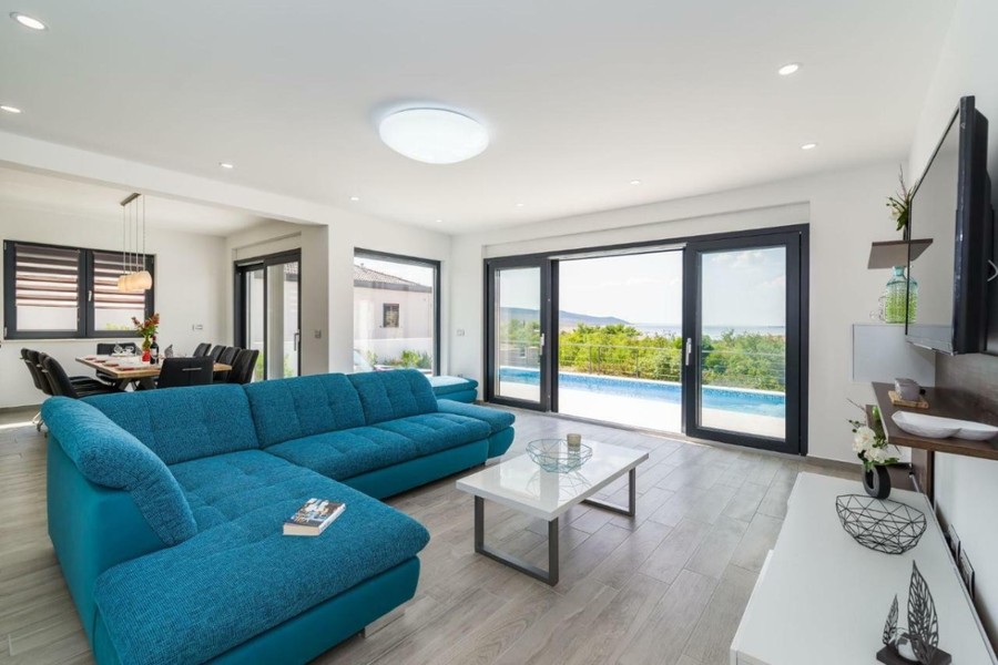 Salon avec façade vitrée donnant sur la piscine