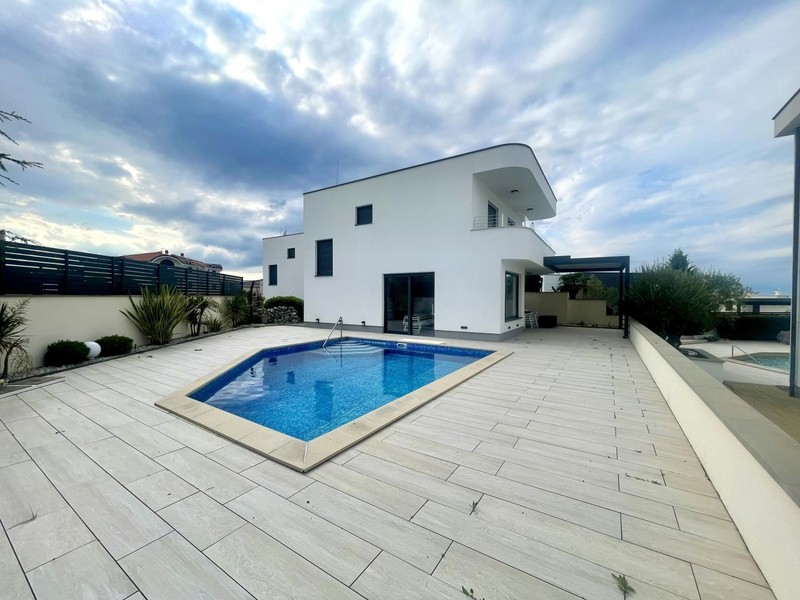 Piscine avec terrasse devant la maison blanche