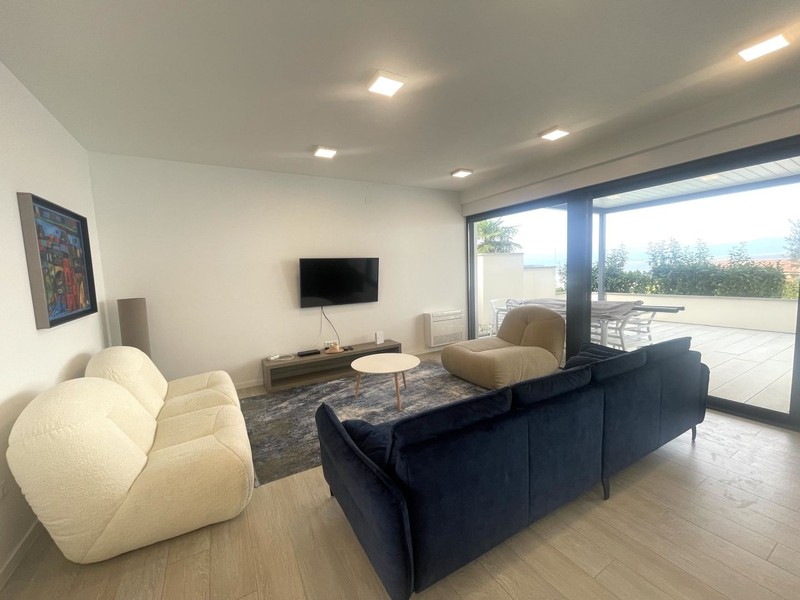 Salon avec fauteuils et grande baie vitrée