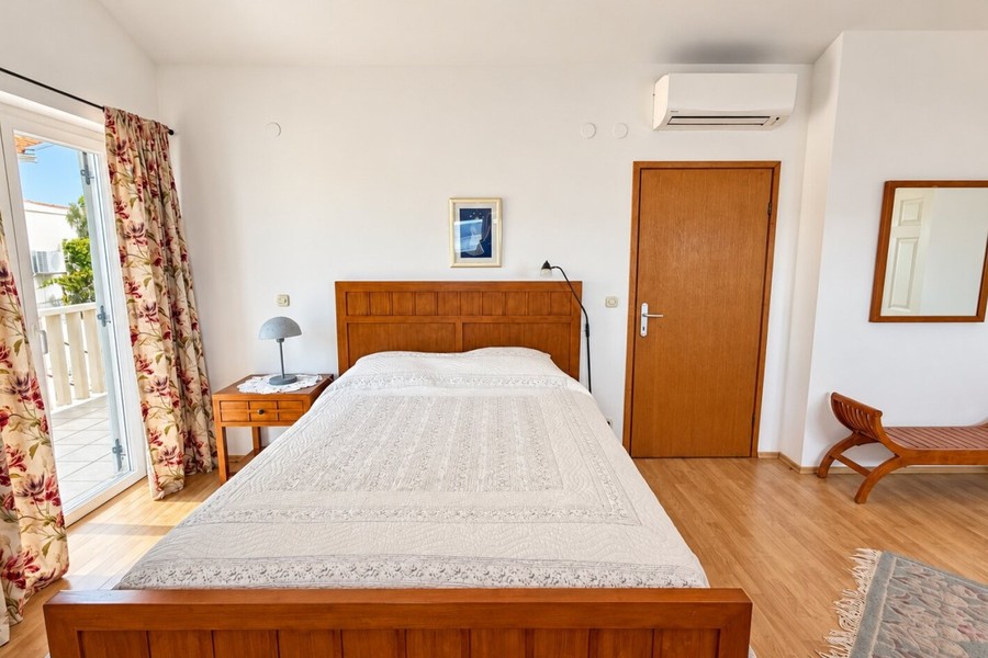 Chambre avec lit en bois et climatisation