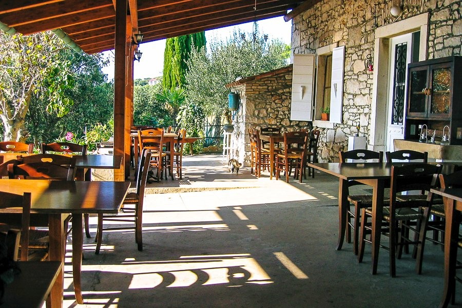 Terrasse couverte avec tables devant la maison en pierre