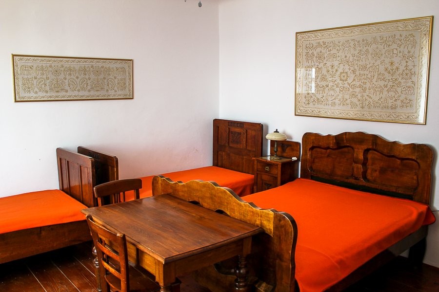 Chambre avec trois lits et table en bois
