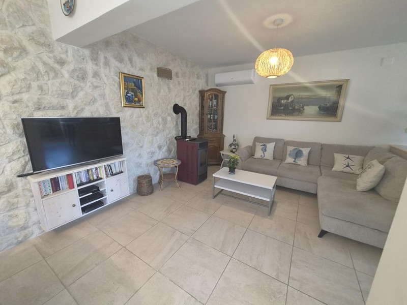 Séjour avec mur en pierre naturelle et poêle à granulés