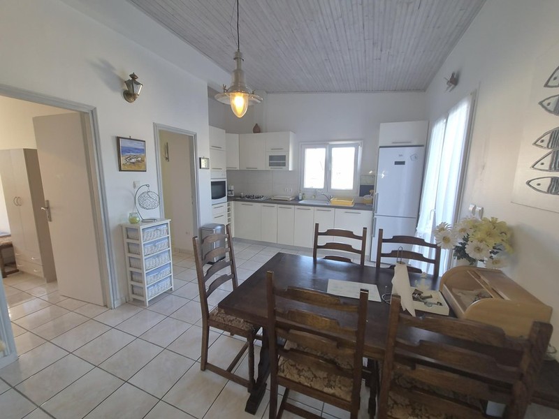 Coin repas avec table en bois devant la cuisine